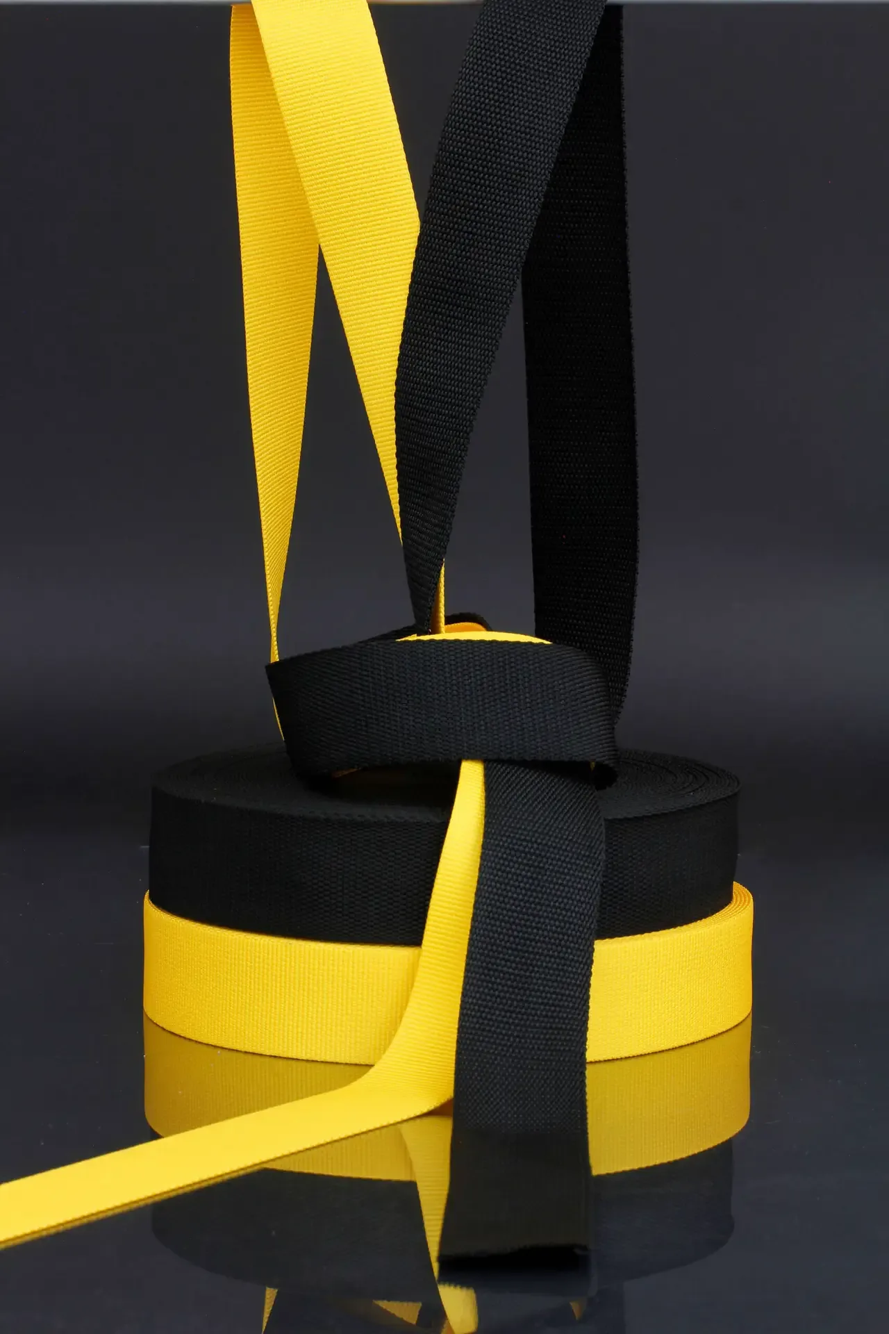 Black and yellow load-bearing webbing rolled in rolls